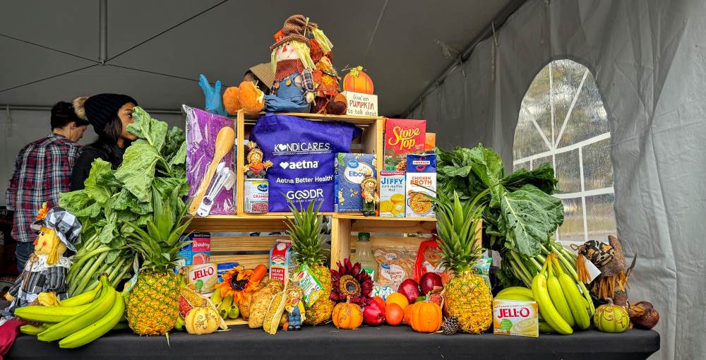 Crates decorated with fresh flowers, collard greens, fruit, produce, and the Thanksgiving essentials that were given away at the Kandi Cares and Aetna Thanksgiving Pop-Up Grocery Market